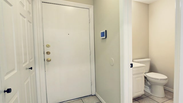 bathroom featuring toilet, baseboards, and tile patterned floors