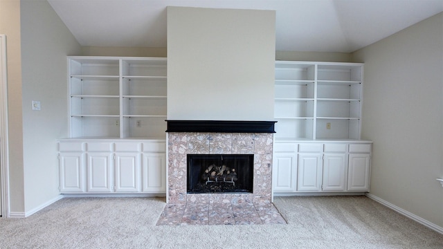 unfurnished living room featuring light carpet, a fireplace, and baseboards