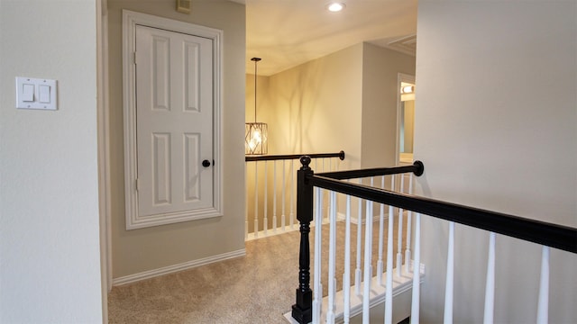 hallway featuring recessed lighting, baseboards, light carpet, and an upstairs landing