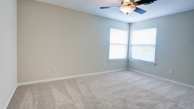 empty room with light carpet, visible vents, baseboards, and a ceiling fan