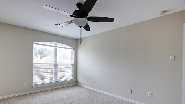 empty room featuring a ceiling fan, light colored carpet, and baseboards