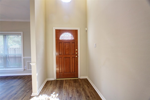 entrance foyer with crown molding, dark wood finished floors, and baseboards