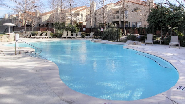 pool featuring a patio area, fence, and a residential view