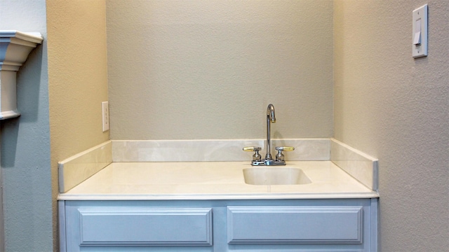 bathroom featuring a textured wall and vanity