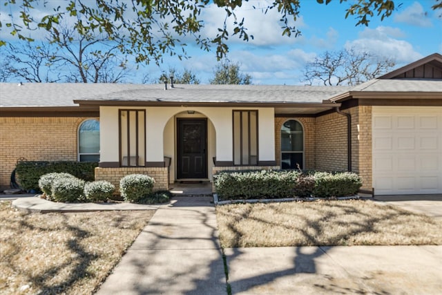 view of exterior entry with brick siding and an attached garage