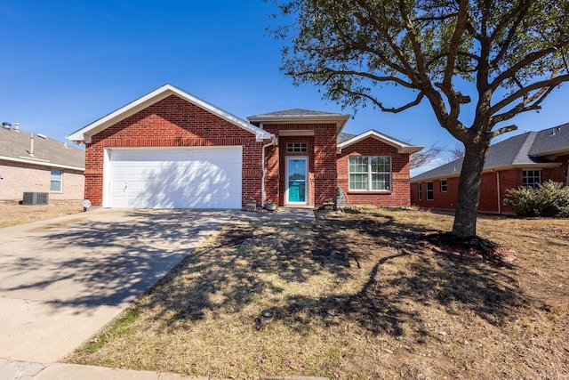 ranch-style home with an attached garage, concrete driveway, central AC, and brick siding