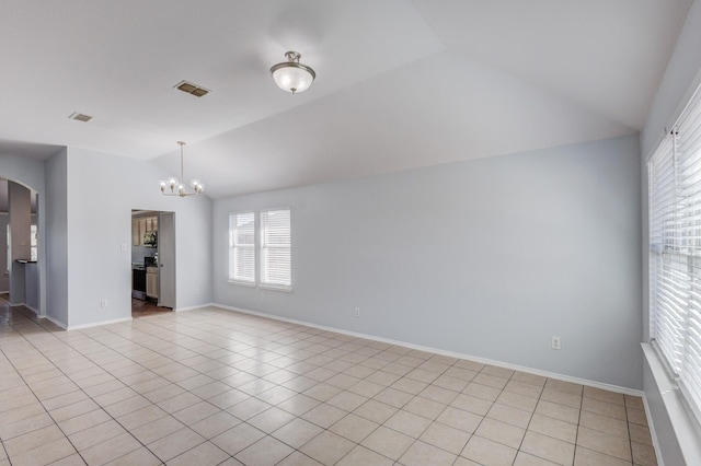 spare room featuring arched walkways, visible vents, vaulted ceiling, and an inviting chandelier