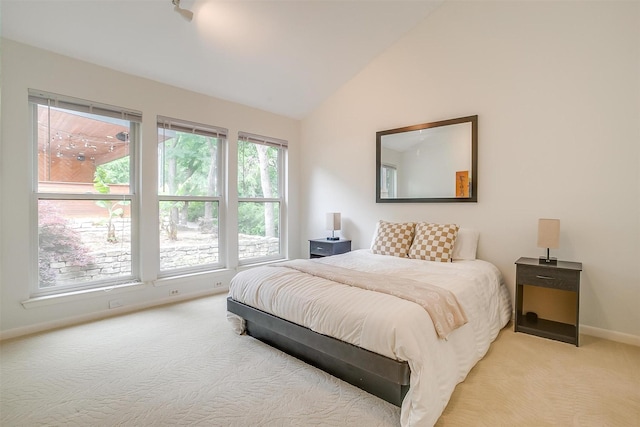 bedroom featuring lofted ceiling, baseboards, and light colored carpet