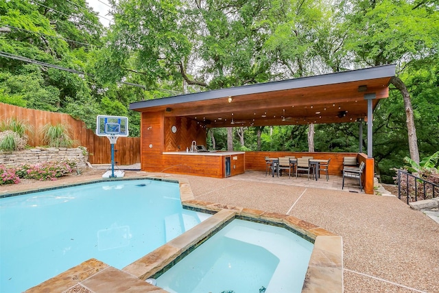 view of swimming pool featuring a fenced in pool, a patio, outdoor dry bar, area for grilling, and fence