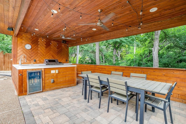 view of patio / terrace featuring a sink, beverage cooler, exterior kitchen, and a ceiling fan