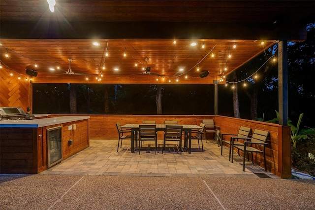 patio at night with exterior kitchen, wine cooler, and an outdoor bar