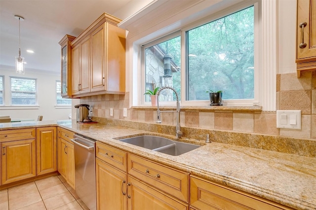 kitchen featuring tasteful backsplash, dishwasher, decorative light fixtures, a sink, and light tile patterned flooring