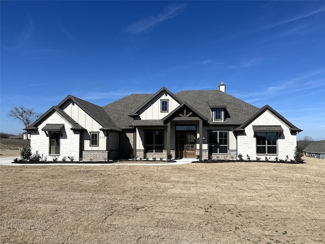 modern inspired farmhouse featuring roof with shingles, a front lawn, and board and batten siding