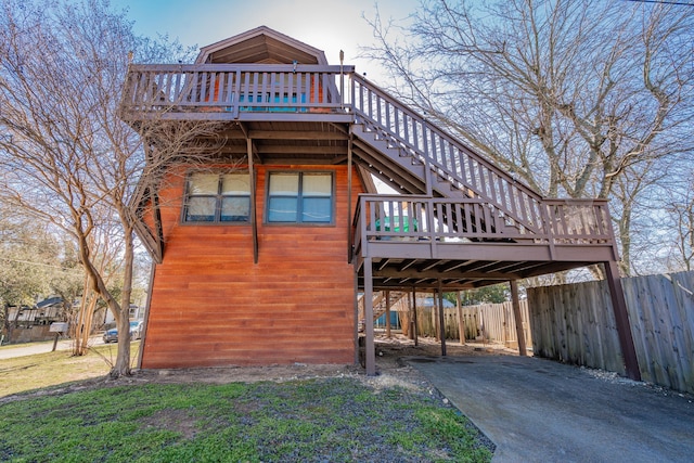 view of home's exterior with stairway, fence, and a wooden deck