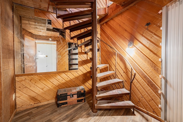 stairs featuring wood walls and wood finished floors