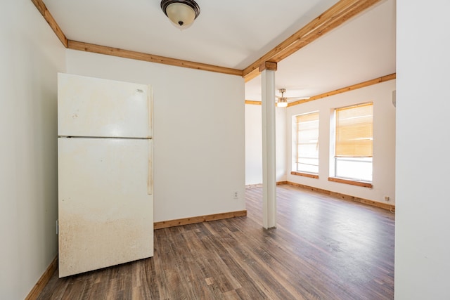 spare room featuring dark wood finished floors, beamed ceiling, and baseboards