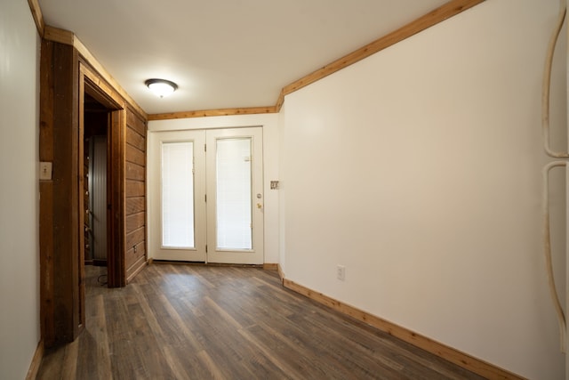 spare room with baseboards and dark wood-style flooring