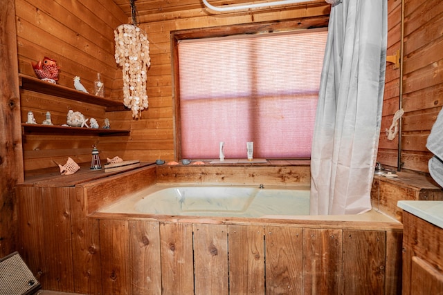 bathroom with vanity, a bath, and wooden walls