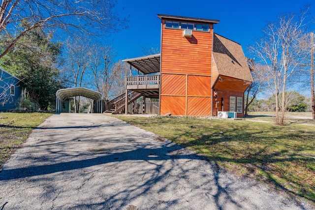 exterior space with a lawn, aphalt driveway, a carport, and roof with shingles