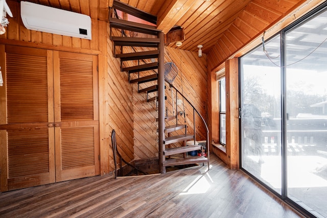 interior space with a wall unit AC, wood walls, and wood finished floors