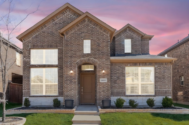 view of front of home with brick siding and a front yard