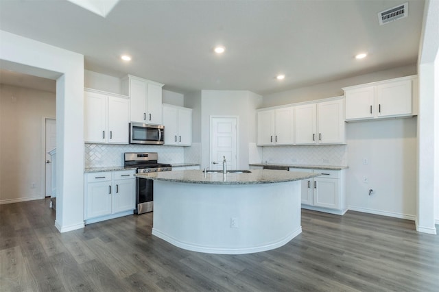 kitchen with appliances with stainless steel finishes, white cabinets, a sink, and an island with sink