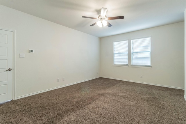 carpeted empty room with ceiling fan and baseboards