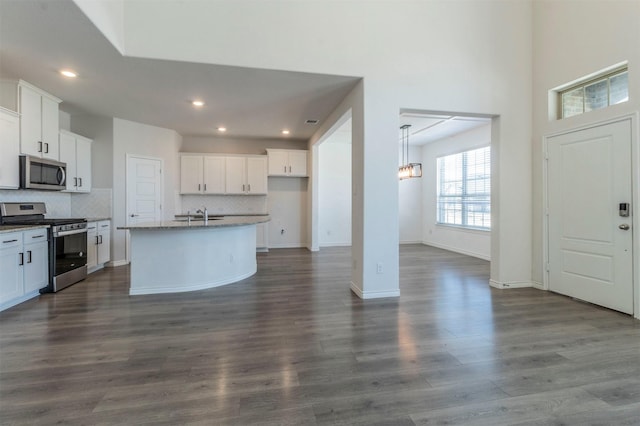 kitchen with white cabinetry, a kitchen island with sink, and appliances with stainless steel finishes