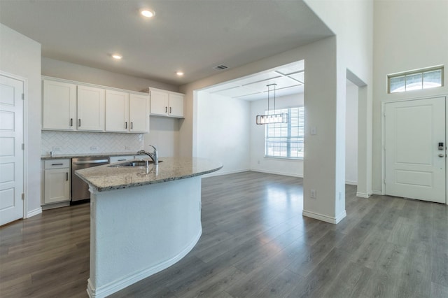 kitchen featuring a kitchen island with sink, white cabinets, dishwasher, and visible vents