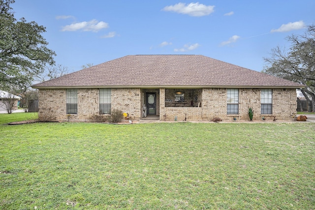 ranch-style home with brick siding, a front lawn, and roof with shingles