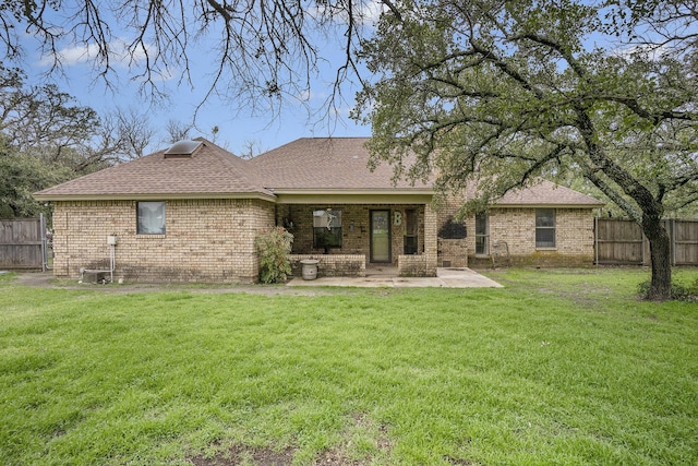 rear view of house featuring brick siding, a patio, a lawn, and fence