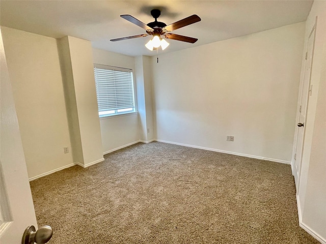 carpeted spare room with ceiling fan and baseboards