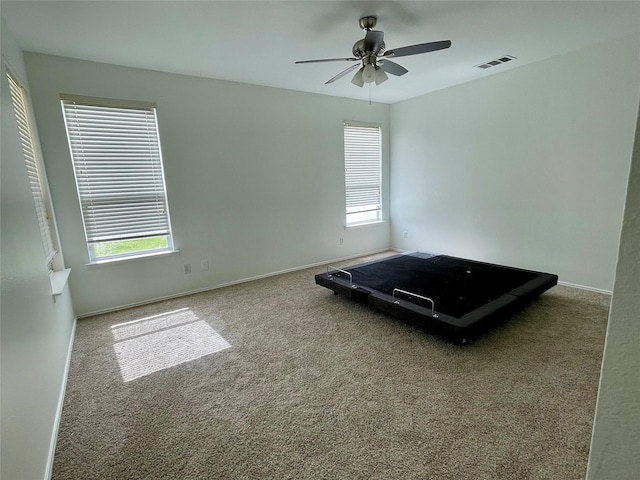 unfurnished bedroom with carpet, visible vents, ceiling fan, and baseboards