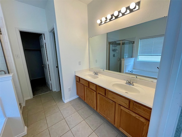 full bathroom featuring a stall shower, tile patterned flooring, a garden tub, and a sink