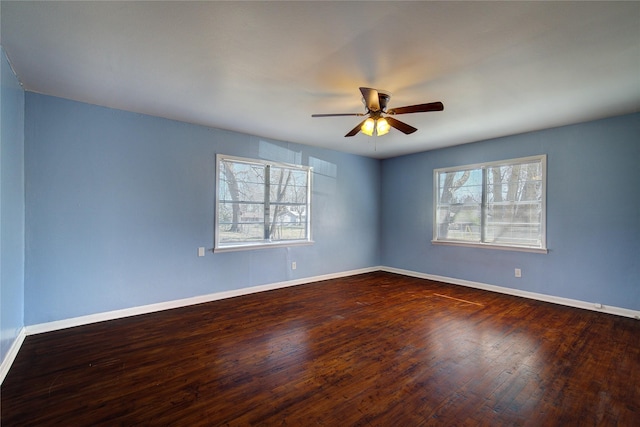 unfurnished room with dark wood-style floors, plenty of natural light, and baseboards