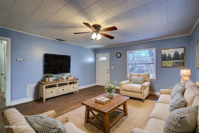 living area with visible vents, wood finished floors, and ornamental molding