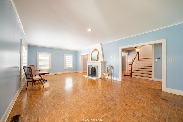 living area with crown molding, stairway, a fireplace, and baseboards