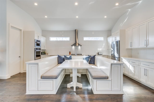 kitchen with breakfast area, a kitchen island, stainless steel fridge, and white cabinetry