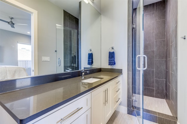 full bath featuring a shower stall, a ceiling fan, and vanity