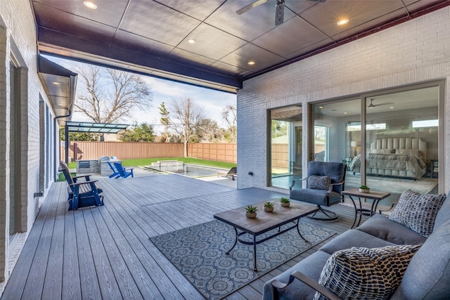 wooden deck with an outdoor hangout area, ceiling fan, and a fenced backyard