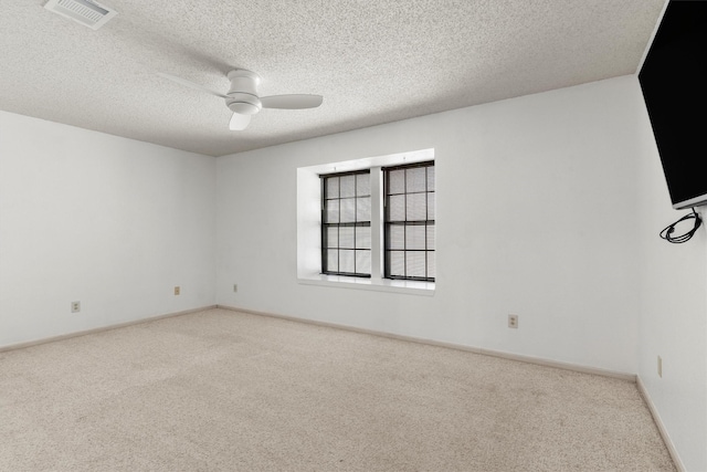 unfurnished room with visible vents, baseboards, carpet, and a ceiling fan