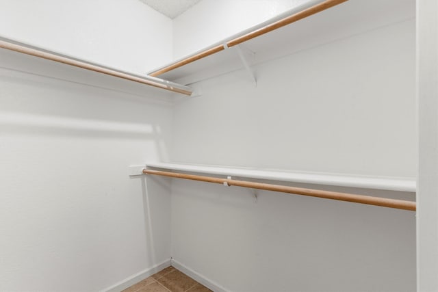 spacious closet with light tile patterned floors