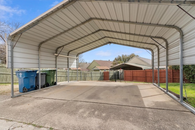 view of vehicle parking featuring a detached carport and fence