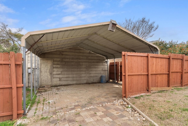 view of outbuilding featuring a detached carport and fence