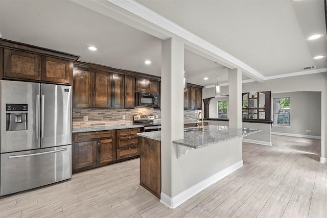 kitchen with stainless steel appliances, light stone counters, backsplash, and dark brown cabinets