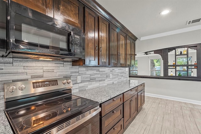 kitchen featuring light stone counters, ornamental molding, stainless steel range with electric cooktop, dark brown cabinets, and black microwave