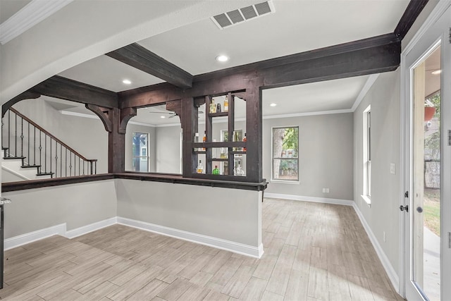 entrance foyer featuring arched walkways, visible vents, light wood finished floors, beamed ceiling, and crown molding