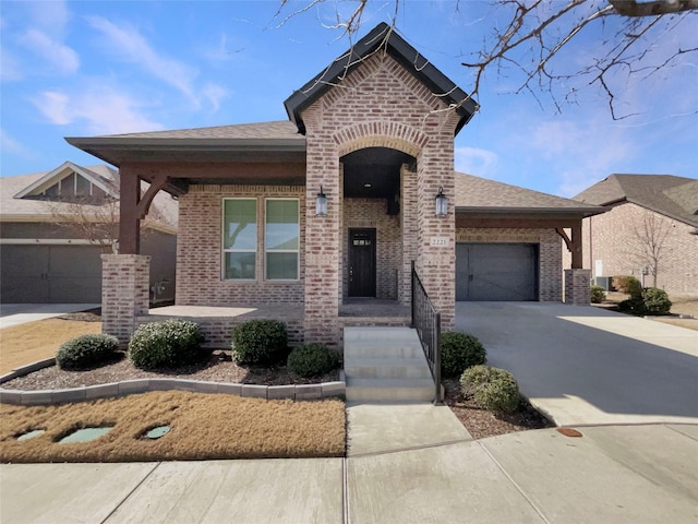 view of front facade featuring a garage, driveway, brick siding, and a shingled roof