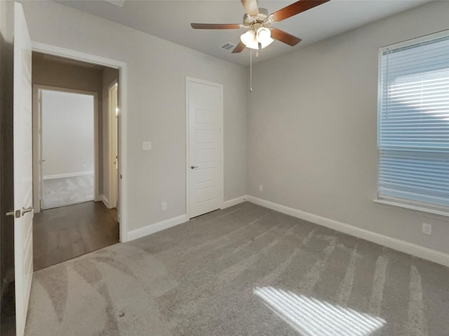 unfurnished bedroom featuring a ceiling fan, carpet, visible vents, and baseboards