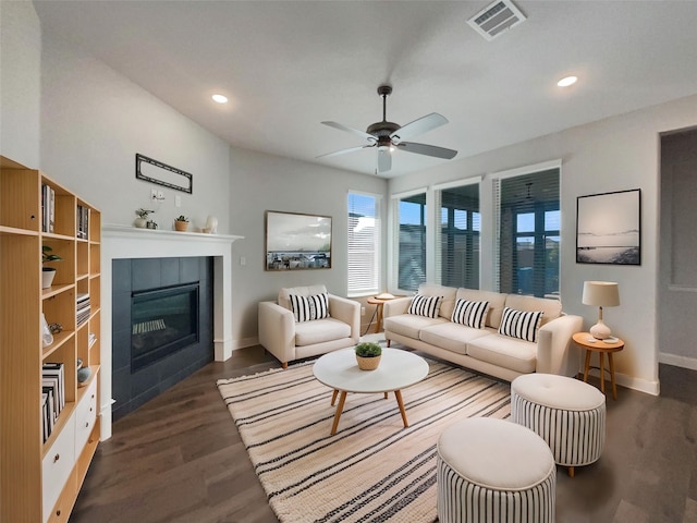 living room featuring baseboards, visible vents, wood finished floors, a fireplace, and recessed lighting